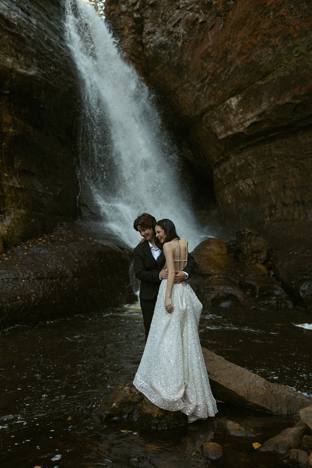 LGBTQ+ couple on their wedding day under a waterfall in Michigan's upper peninsula