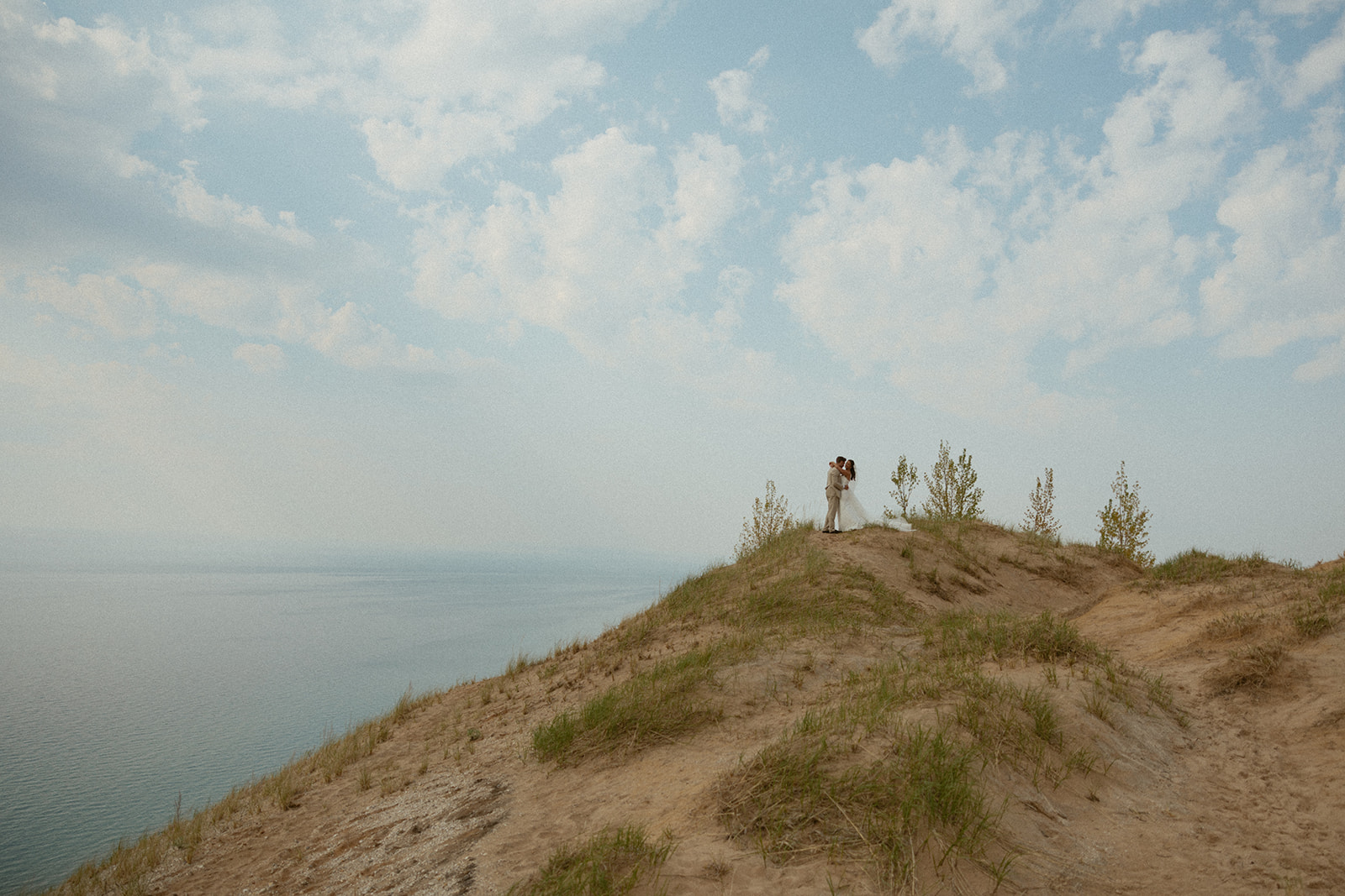 Couple on a sand dune at their elopement at Pierce Stocking drive at Sleeping Bear Dunes 